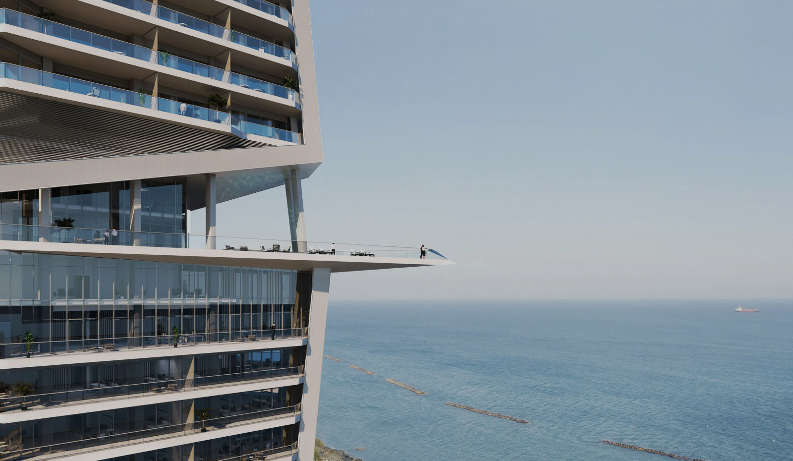 Man stands on balcony of high rise appartment overlooking sea